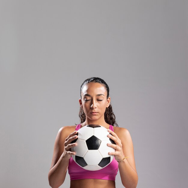 Caber mulher segurando bola de futebol