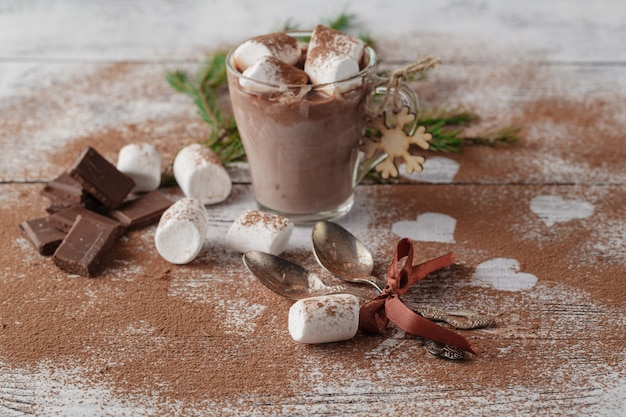 Cacau, café com leite ou chocolate quente com marshmallow e aromatizado com canela. em uma mesa de madeira presente de natal Foto Premium