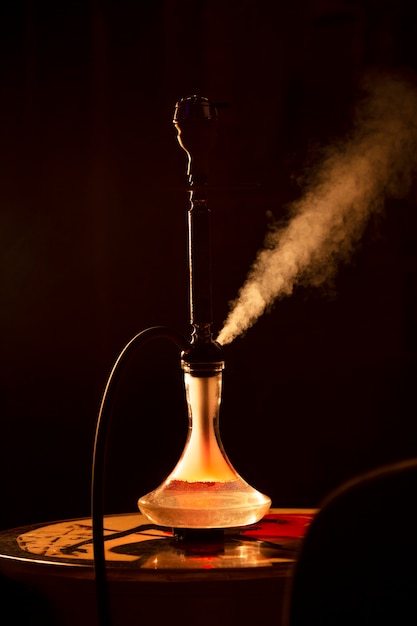 Cachimbo de água de vista frontal em um bar com neblina ao redor