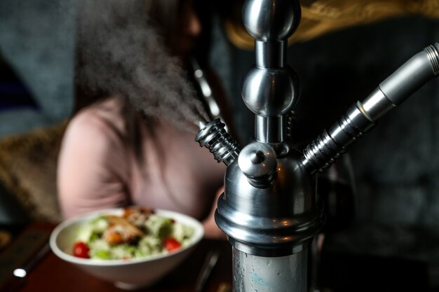 Cachimbo de água enquanto fuma na vista de perto da mesa