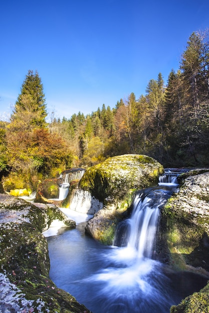 Cachoeira pequena na montanha com gelo em Ain, França