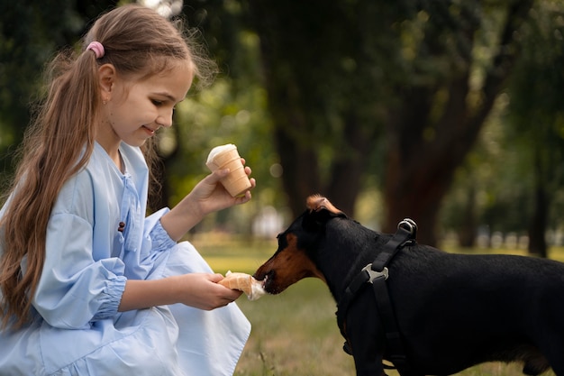 Cachorro alimentando menina com tiro médio