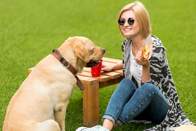 Foto grátis cachorro olhando para sanduíche e mulher sorrindo