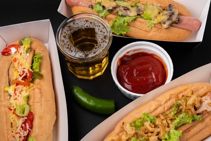 Foto grátis cachorro-quente com ângulo alto com ketchup e bebida