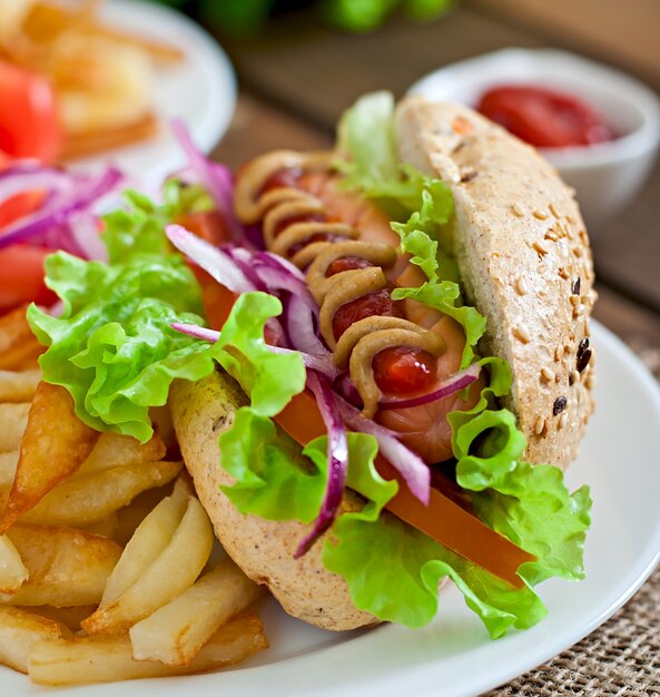 Cachorro-quente com mostarda de ketchup e alface na superfície de madeira.