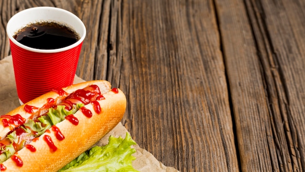 Foto grátis cachorro-quente com refrigerante e copie o espaço