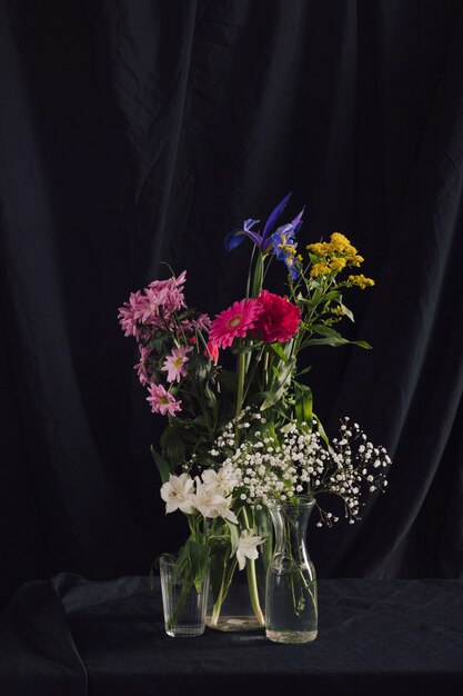 Cachos de flores coloridas em vasos com água