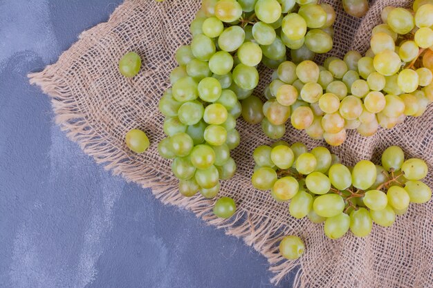 Cachos de uva verde em um pedaço de serapilheira.