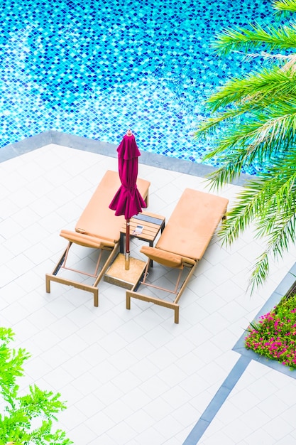 Foto grátis cadeira de guarda-chuva em torno da piscina