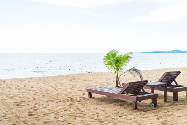 Cadeira de praia, Palm e praia tropical em Pattaya na Tailândia