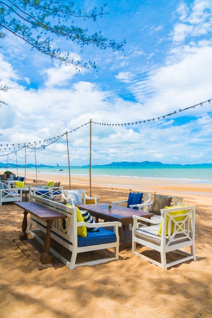 Cadeira e mesa de jantar na praia e no mar com céu azul