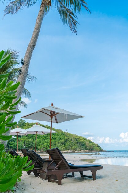cadeiras de praia bonitas com guarda-chuva na pra areia branca tropical