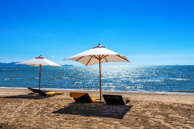 Cadeiras e guarda-chuva em uma praia tropical.