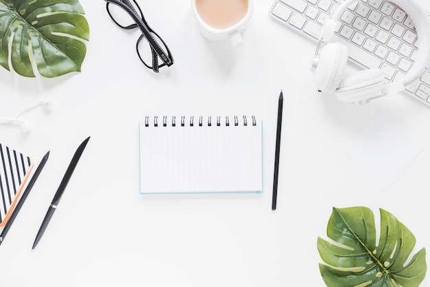 Foto grátis caderno aberto perto de artigos de papelaria e dispositivos eletrônicos