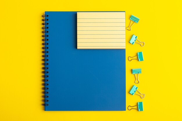 Foto grátis caderno azul aberto de vista frontal na mesa amarela