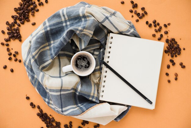 Caderno de vista superior com café no pano