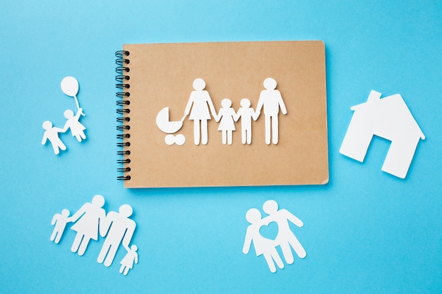 Foto grátis caderno de vista superior com papel cortado conceito de família