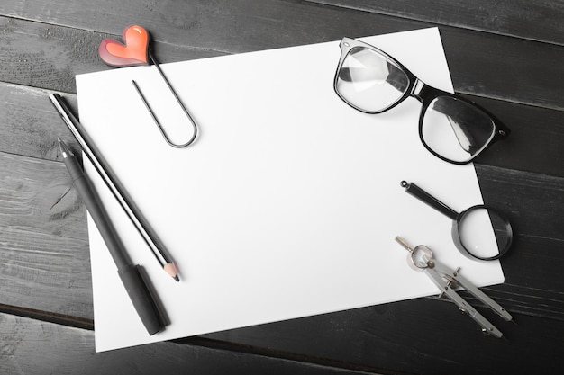 Caderno em branco e lápis com óculos na mesa de madeira