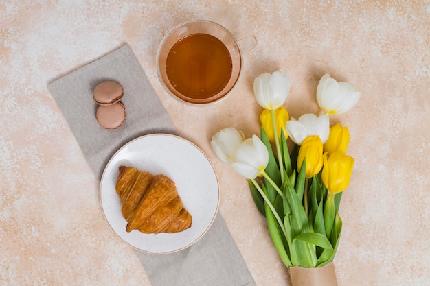 Café da manhã com croissant e flores