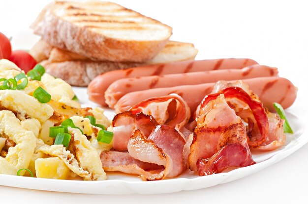 Café da manhã inglês - ovos mexidos, bacon, linguiça e torradas