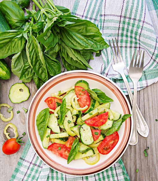 Café da manhã no jardim de verão. Salada de tomate e pepino com cebolinha e manjericão.