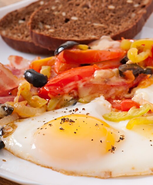 Café da manhã - ovos fritos com bacon, tomate, azeitona e fatias de queijo