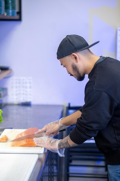 Café de sushi. Sushi chef cortando peixe e fazendo sushi