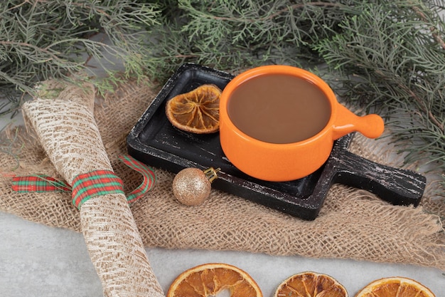 Café e fatias de laranja em tabuleiro escuro com decoração de natal