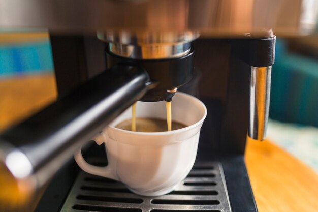 Café expresso quente derramando em porcelana caneca