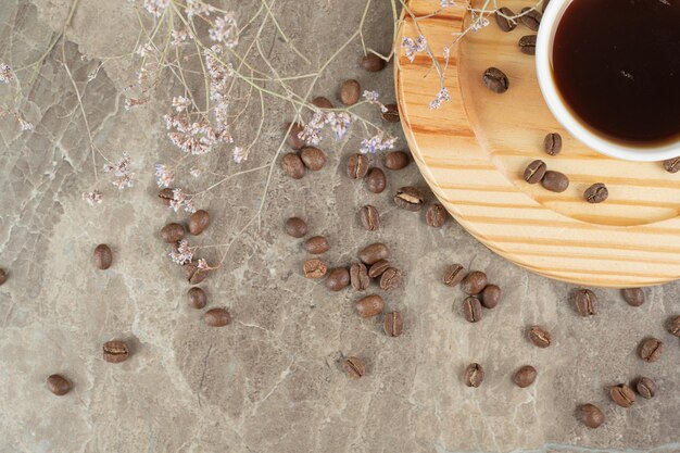 Café no prato de madeira com grãos de café