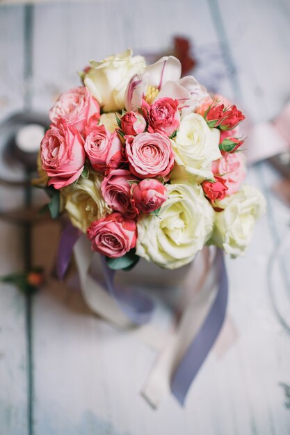 Caixa com ramos de bouquet branco e laranja na ta de trabalho da florista