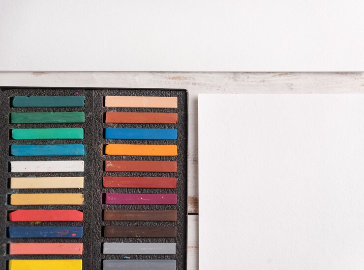 Foto grátis caixa com tinta pastel colorida em papel branco