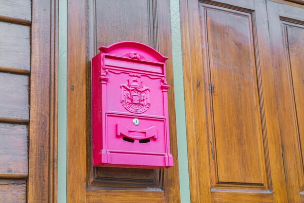 caixa de correio vermelha na parede de madeira