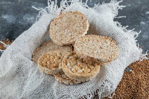 Caixa de pão crocante arejado e trigo sarraceno cru na superfície de mármore