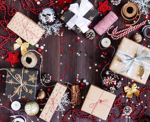 Caixa de presente de feriado de Natal na mesa festiva decorada com pinhas candy cane vela bola