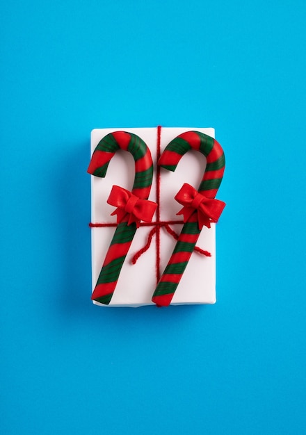 Caixa de presente de Natal com fita vermelha decorada com bastões de doces