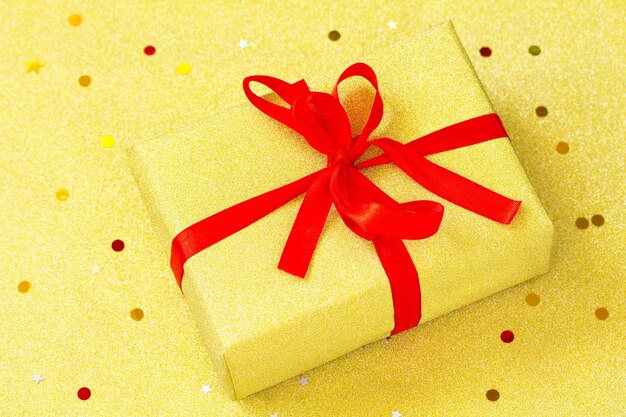 Caixa de presente de natal feita à mão com fundo dourado caixa de presente de natal dourada com fita vermelha