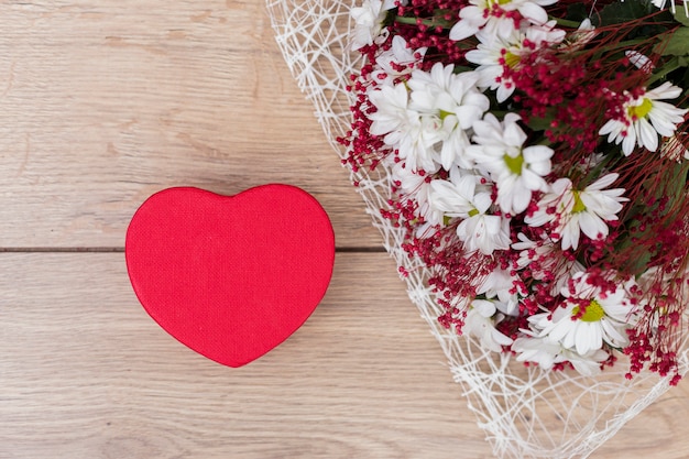 Foto grátis caixa de presente em forma de coração com buquê de flores