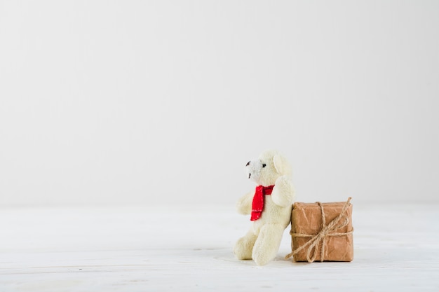 Caixa de presente pequena com urso branco na mesa