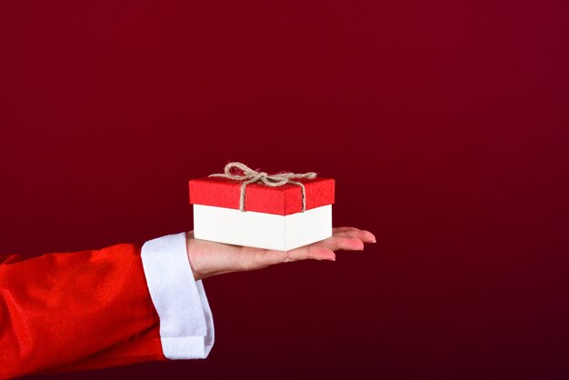 Caixa de presentes na mão da mulher vestida com o vestido de Papai Noel