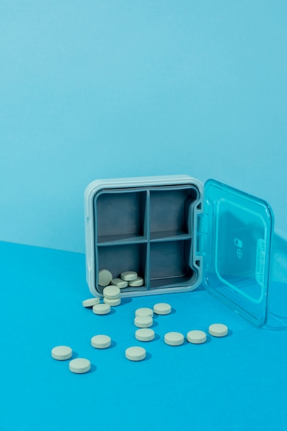 Foto grátis caixa e comprimidos com fundo azul