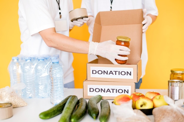 Caixas de doação sendo preenchidas com comida