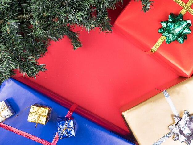 Caixas de presente de Natal e árvore de Natal em fundo vermelho. Ornamento de tradição.