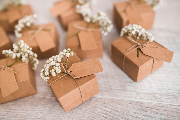 Caixas de presente de papelão com tag e flores de respiração do bebê na mesa de madeira