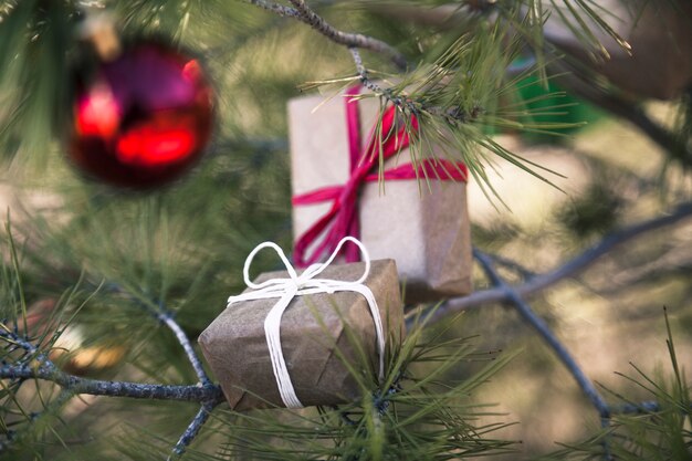 Caixas de presente e bola de natal vermelha na árvore