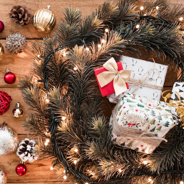 Foto grátis caixas de presentes entre grinalda de abeto perto de senões e bolas de natal