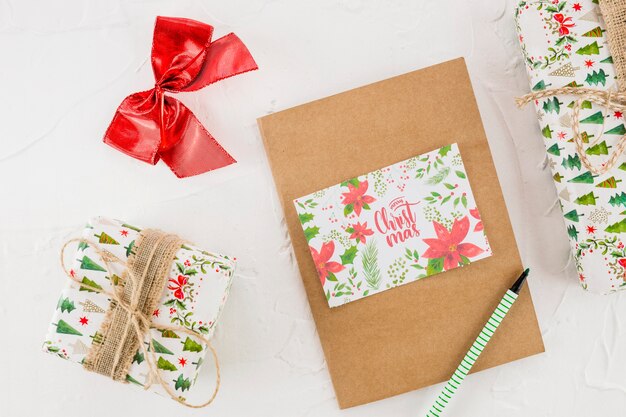 Caixas de presentes entre tablet, caneta, arco e cartão postal