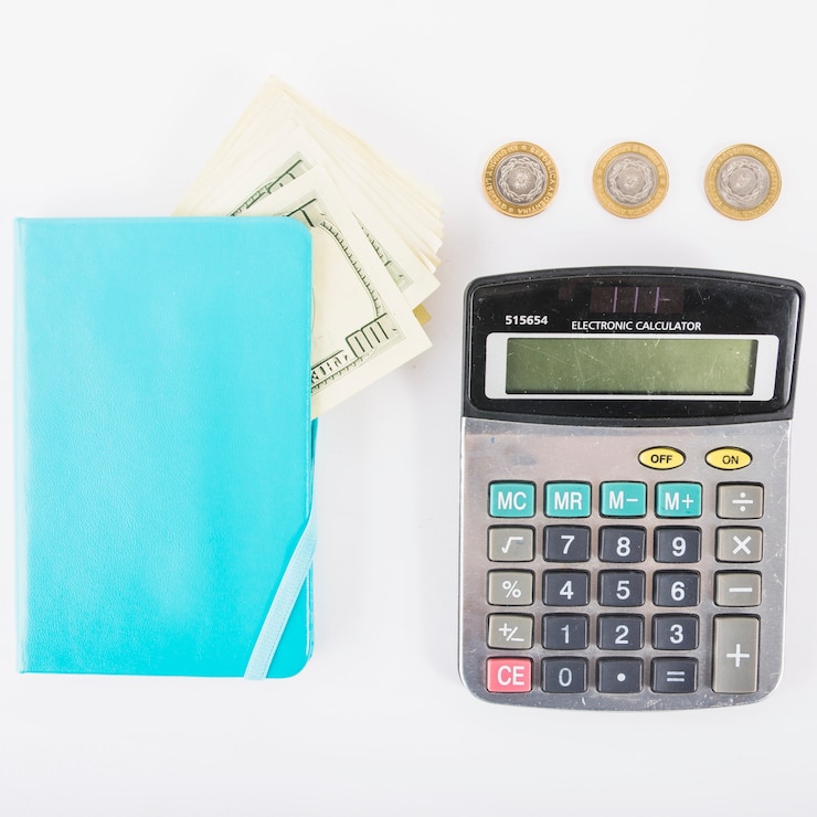 Foto grátis calculadora com dinheiro e notebook na mesa