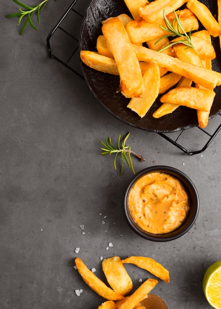 Camada plana de batatas fritas na grelha de resfriamento com mostarda