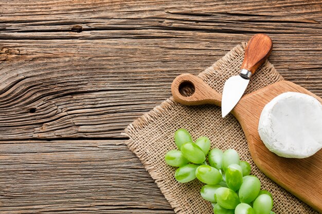 Camembert e leigos planos leigos na tábua de madeira com espaço de cópia